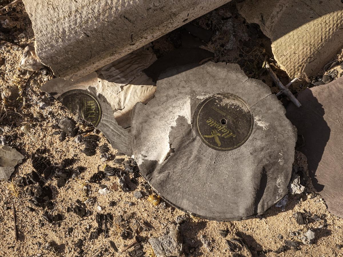 Two decaying 78 RPM records lying in desert sand, with labels DECCA and Majestic.
