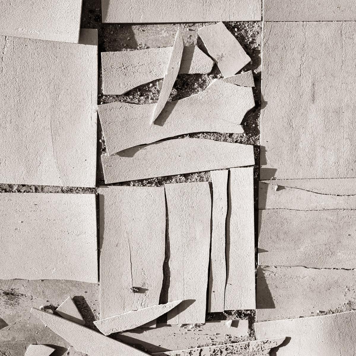 Whole and broken floor tiles lit by sunrise.