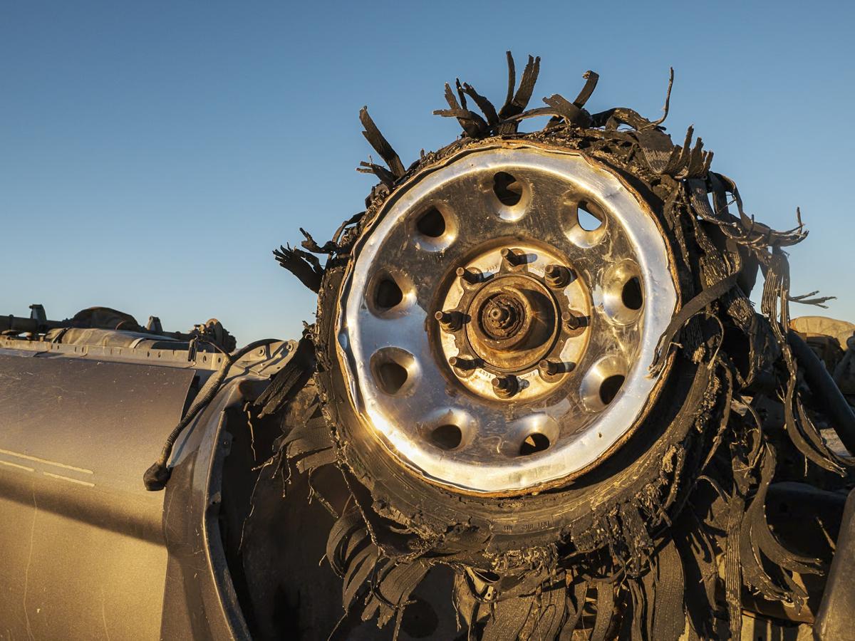 Wheel of abandoned car reflects sunrise light.