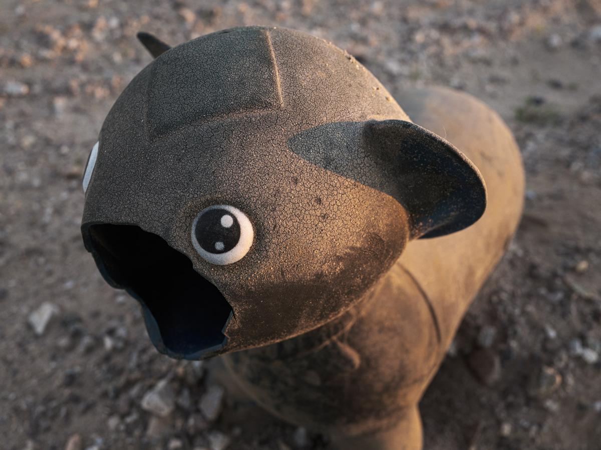 A plastic cat with mouth broken off.