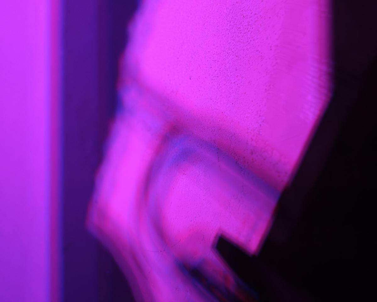 Shadow of trumpeter cast by multiple colored stage lights.